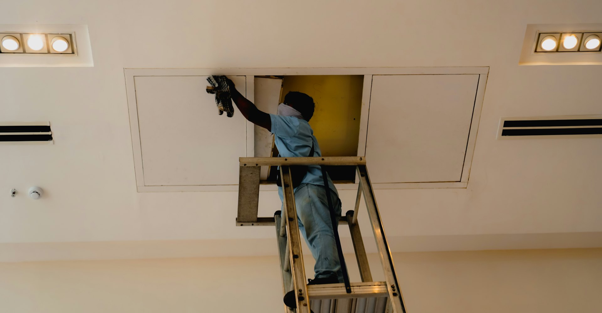 Schilder in witte werkkledij aan het werk aan een binnenmuur